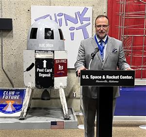 Dr, Nichols at podium with postbox in background
