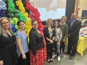 PTA leaders  on stage by colorful balloons