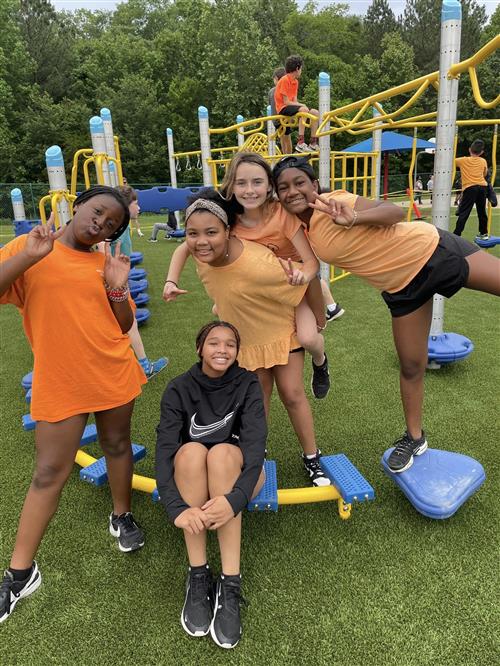 girls posing in front of playground equipment