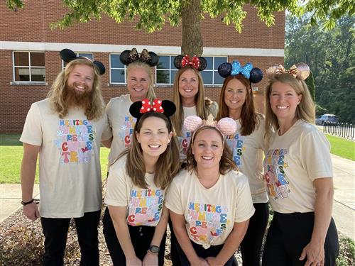 teachers in  matching shirts outside school
