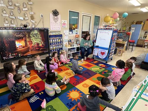 PreK kids seated around carpet engaged in learning activity