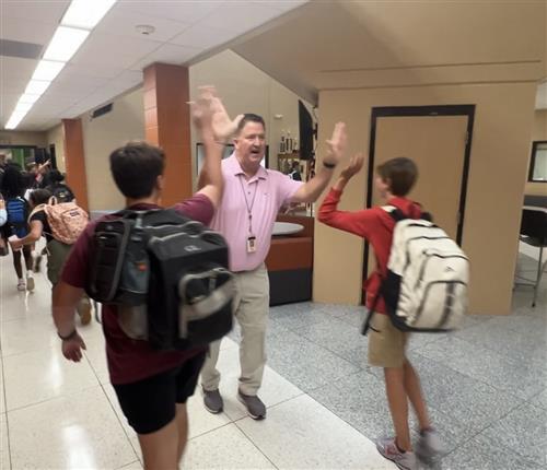 Prncipal Shannon Brown high-fiving  students at Liberty Middle School