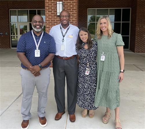 board vice president Travis Cummings with Midtown Elementary admins in front of school