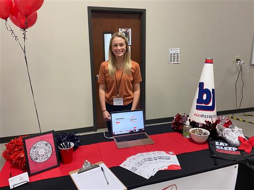 Student at table with swag of her cheerleading training business