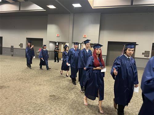 BJ grads walking in procession toward arena for graduation ceremony start