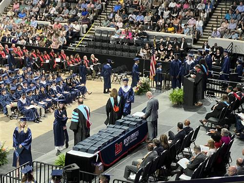 overhead view of BJ graduates walking across stage for diploma