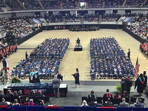 BJ graduates seated on floor of arena