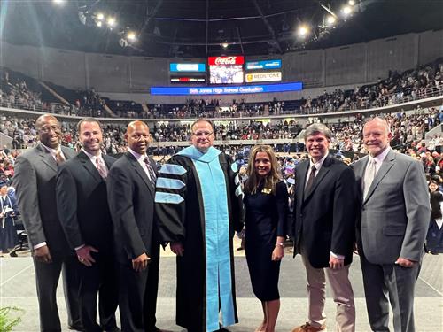 board and superintendent and assistant superintendent on stage at arena 