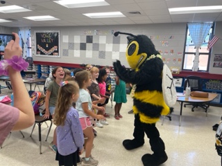 Buzz mascot at Madison Elementary jostling with students