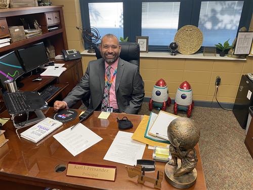 Karl Fernandez seated at desk at Rainbow Elementary