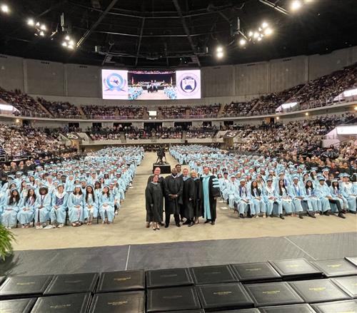 administrators with graduates in background of arena