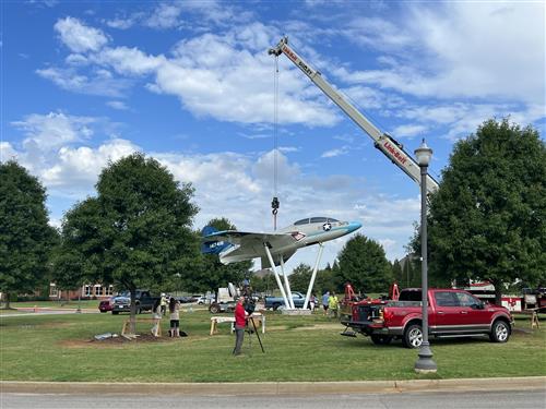 wide angle view of aircraft being hoisted to pedestal