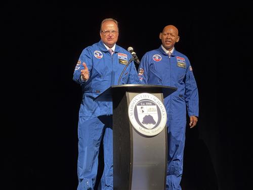 Mr. Terrell and Dr. Nichols in their flight suits at podium