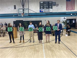 students spelling out $25,000 using placards 