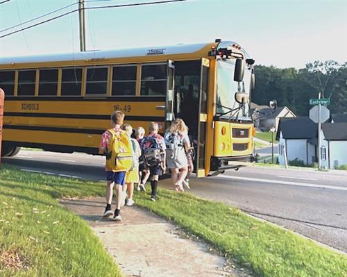 schoolbus being boarded with students