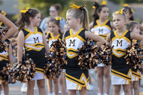 Young girls in cheerleader outfits waiting for their day to be in high school