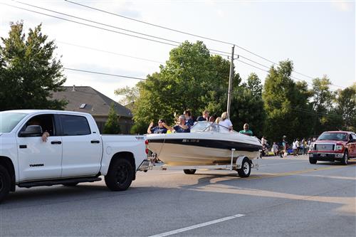 Elementary principals riding in boat being towed in parade