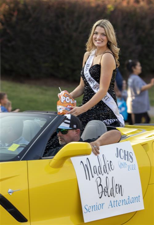 Homecoming attendant riding in convertible