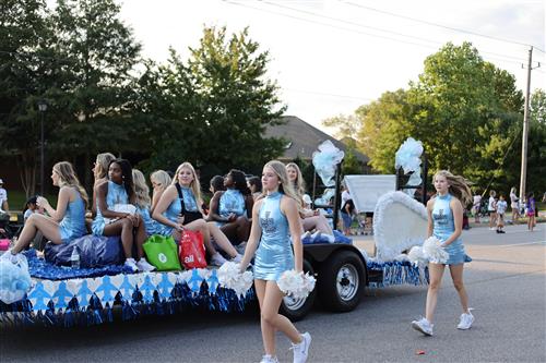 Float with students on it and students walking beside