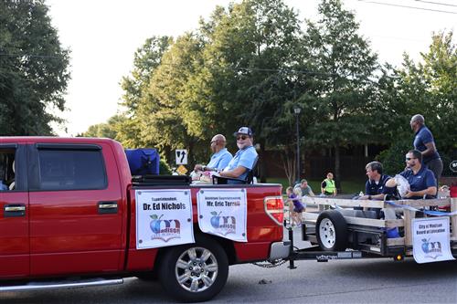 superintendent and assistant superintendent in truck pulling trailer with Board of Education members